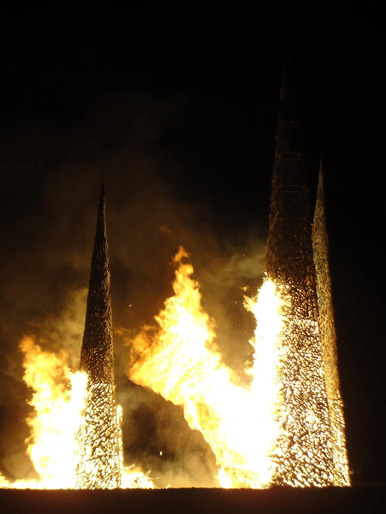 Tall flames from a burning structure at night