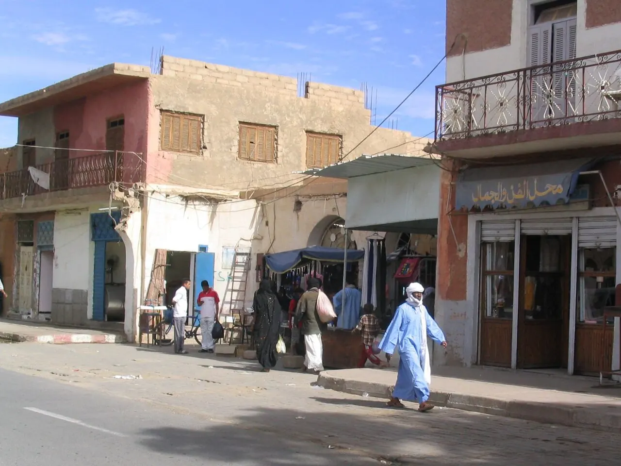 A street in a desert town with a person in a long robe