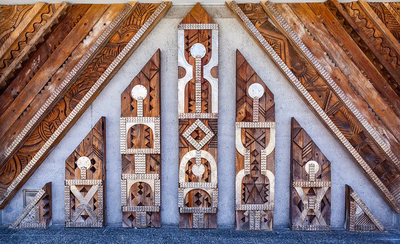 Carved Māori panel patterns on a timber and stone facade