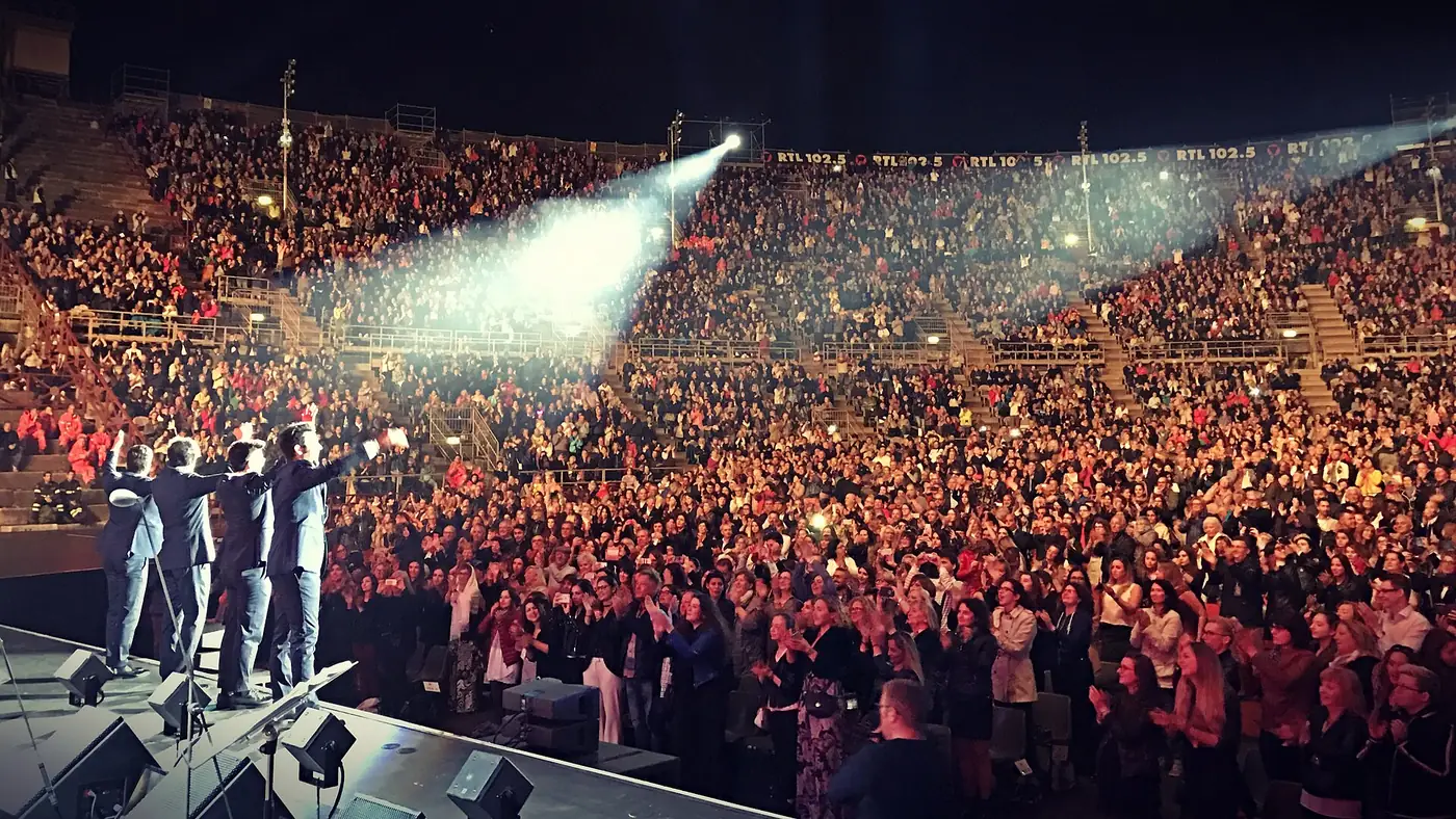 A crowd in the tiers with performers on stage at night