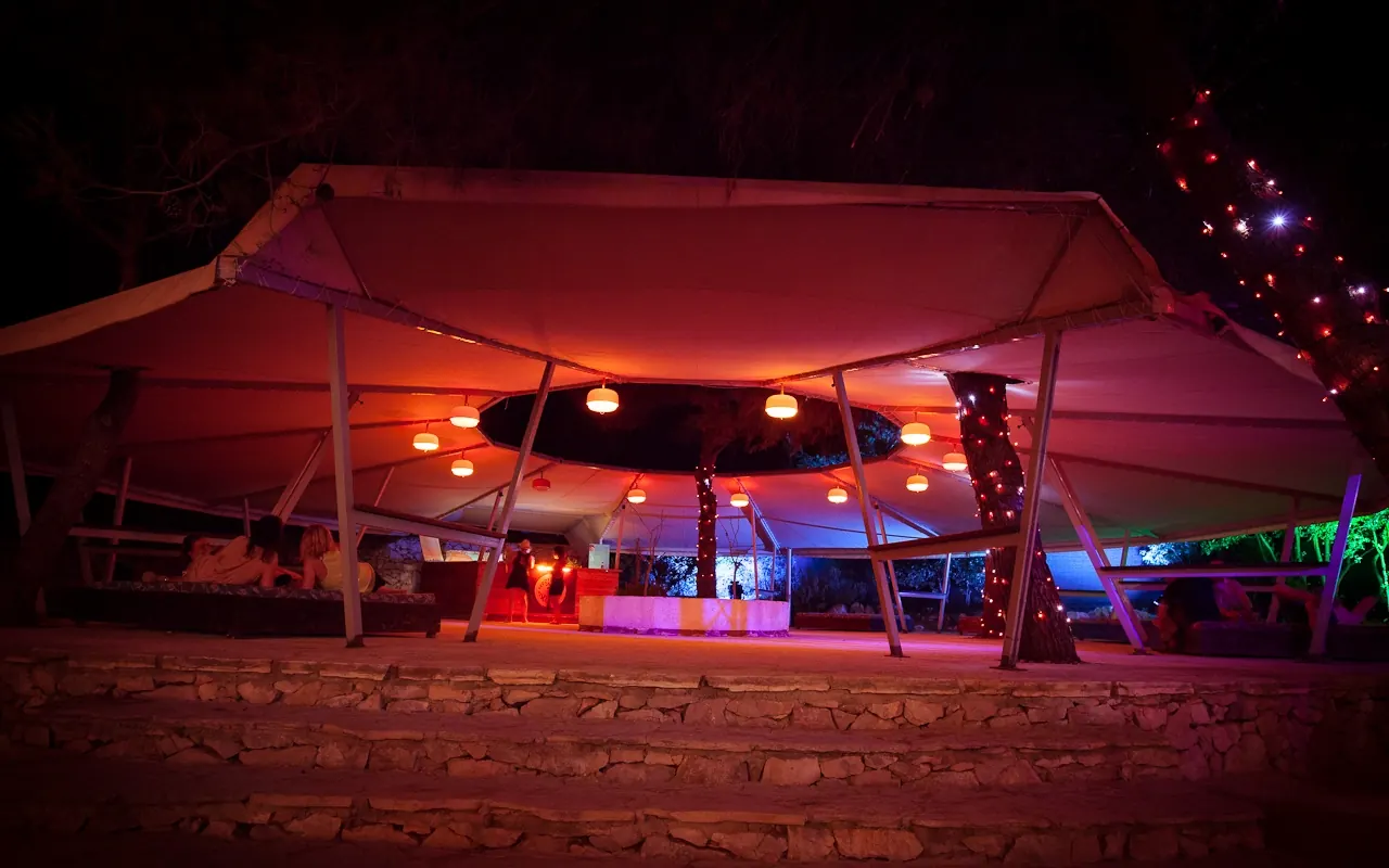 A red-lit tent stage at night