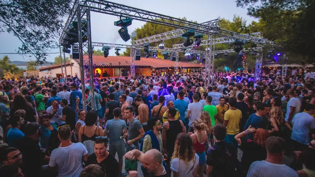A large daytime crowd at an outdoor stage