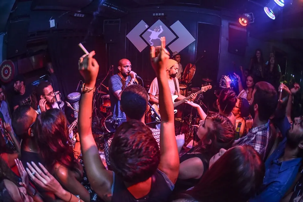 Dancers with raised arms in red light