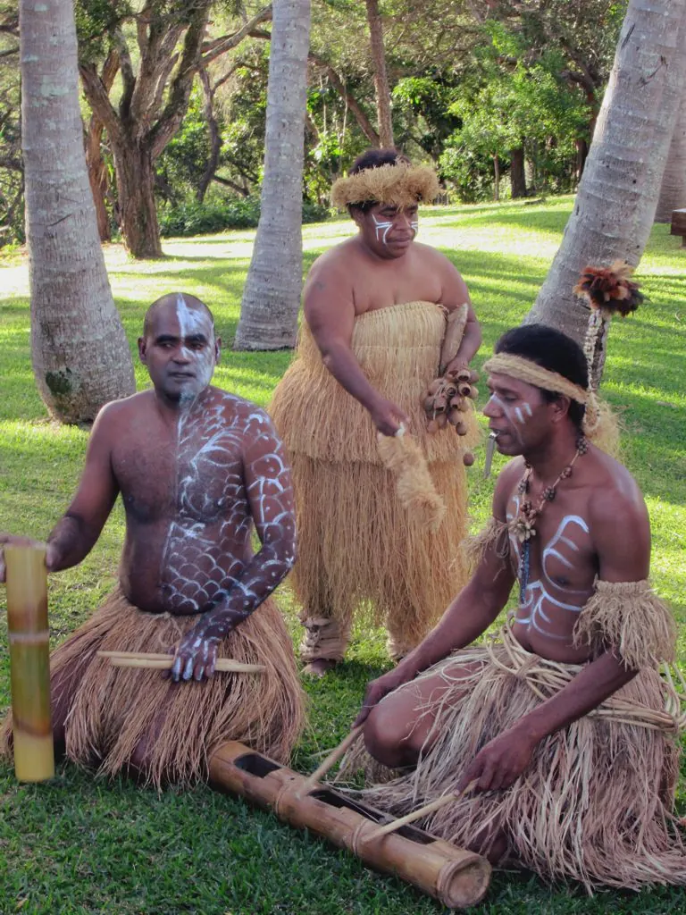 Two men in traditional dress seated on the grass