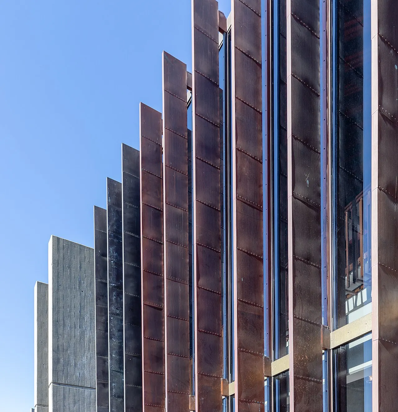 A red-brown fluted tower beside the hall