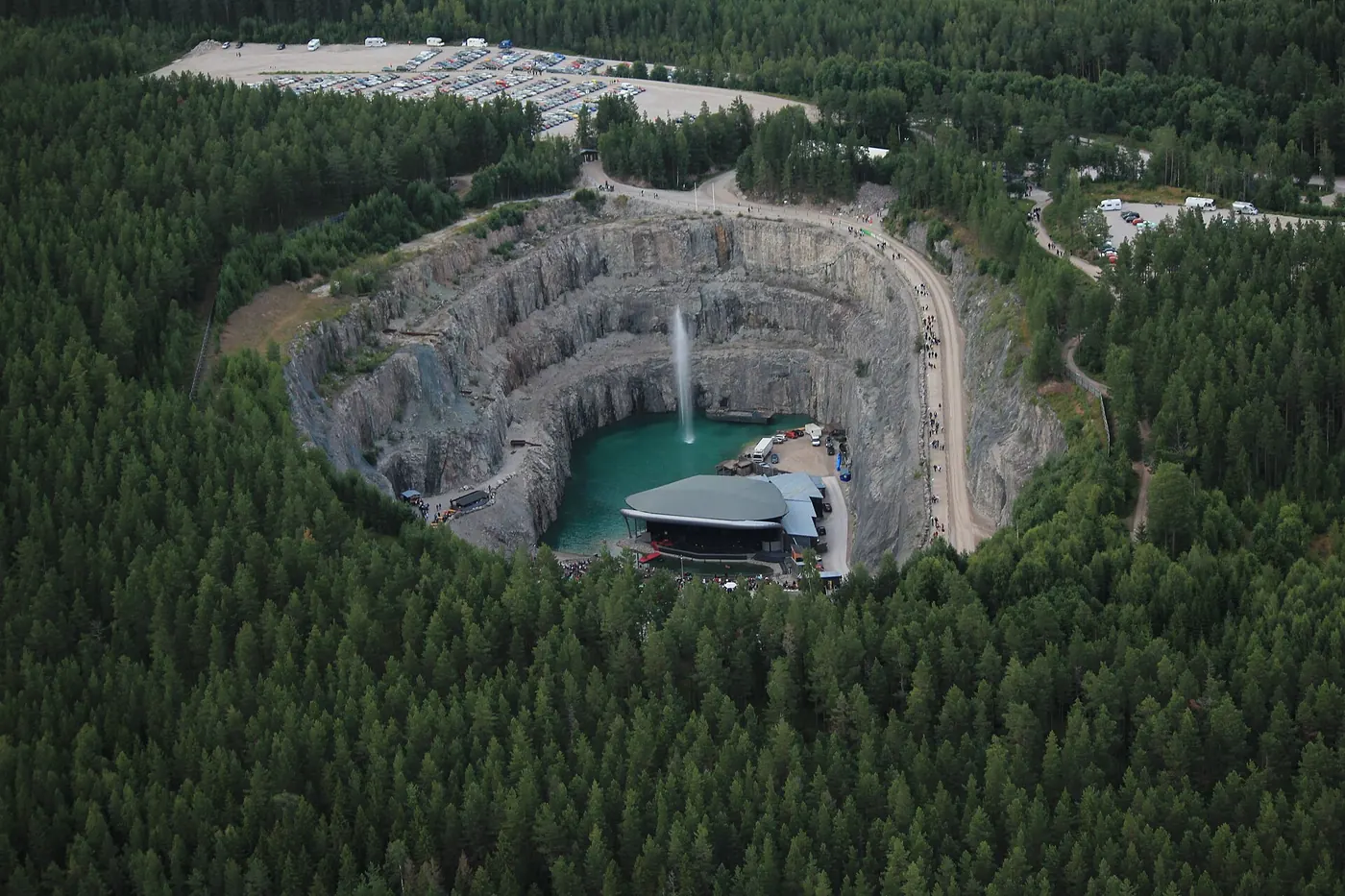 An aerial view of the round quarry among the pine forest