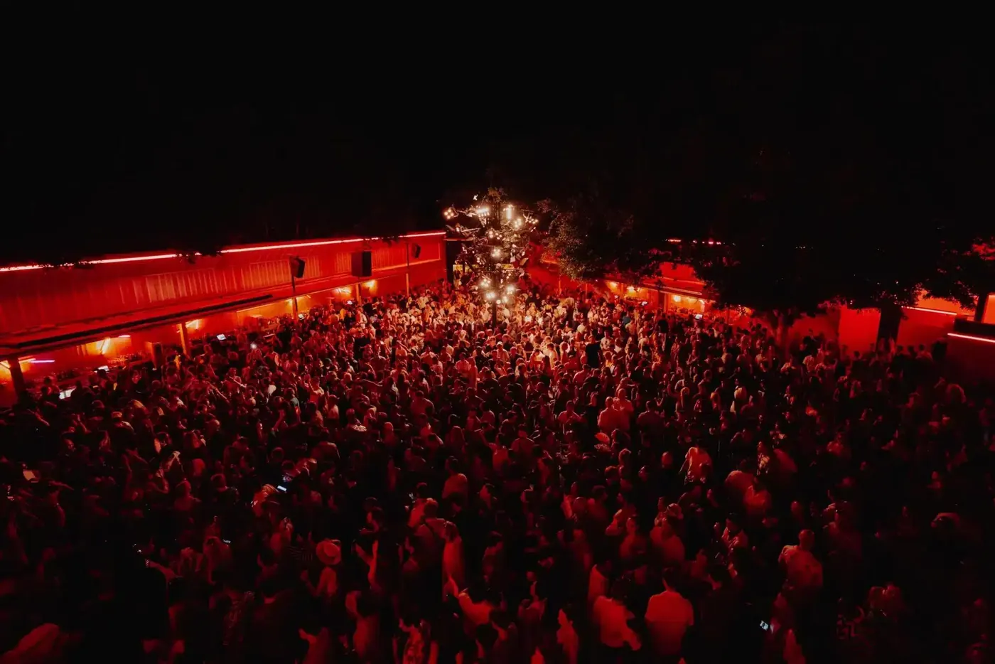 A dark, packed dancefloor lit in red at DC-10