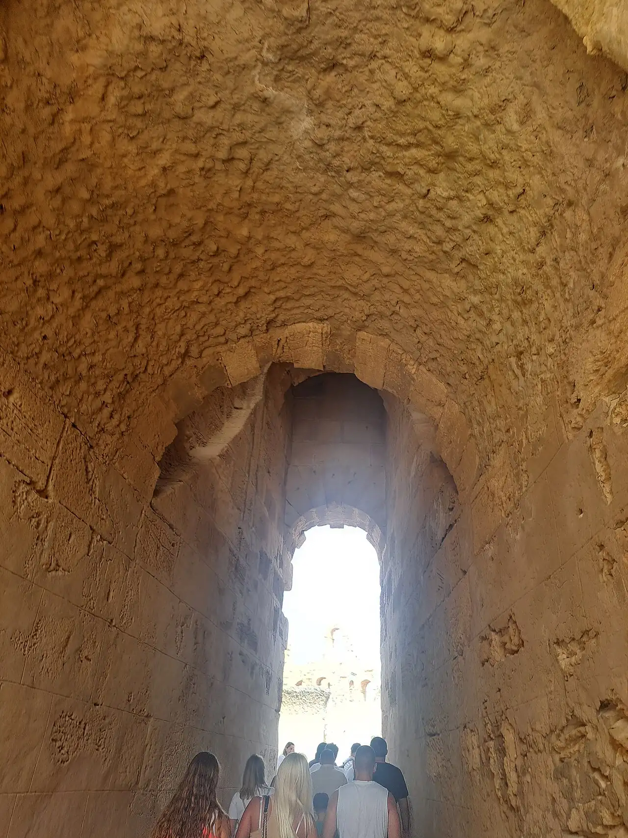 A sunlit arched opening in an old stone wall