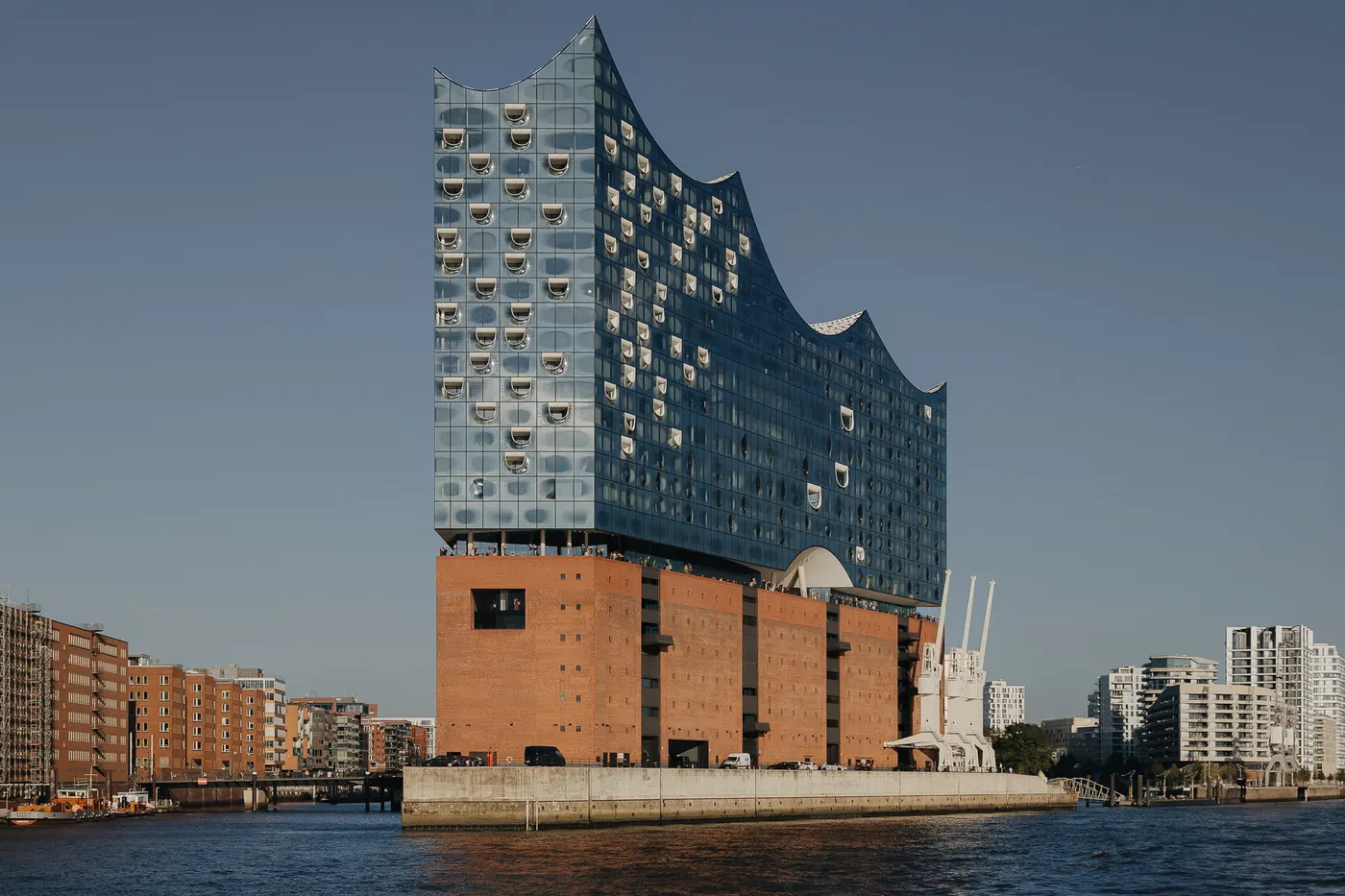 The Elbphilharmonie beside the harbour under a clear sky