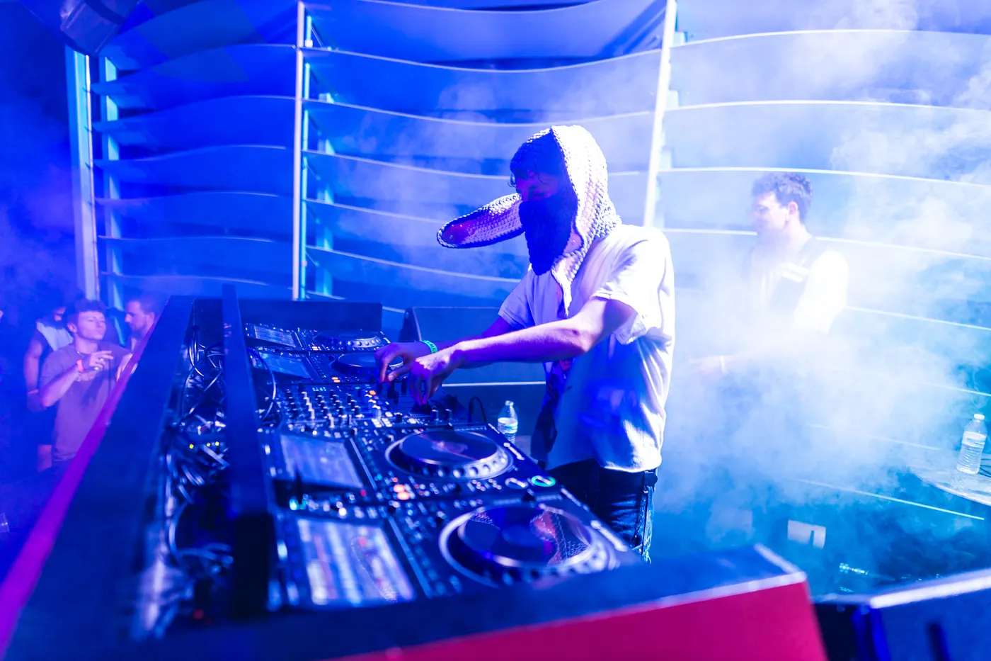 A DJ at the decks in blue light
