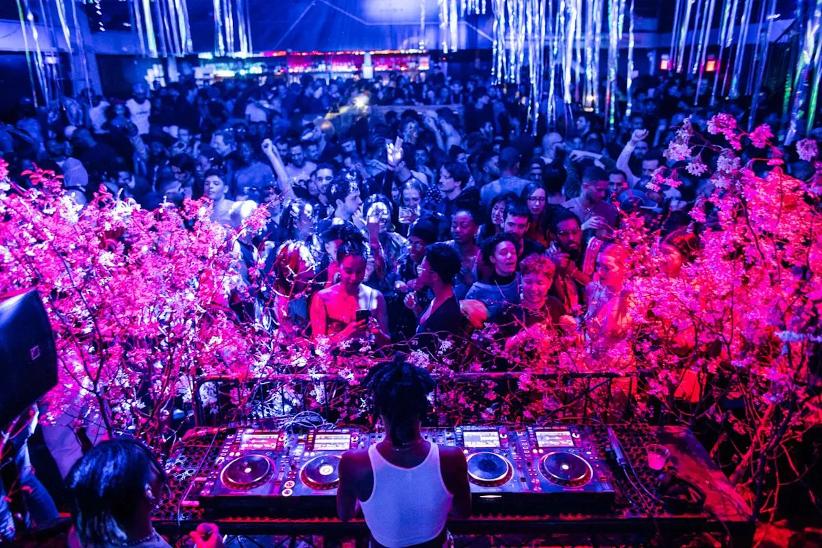 A crowd on the dancefloor under pink lights