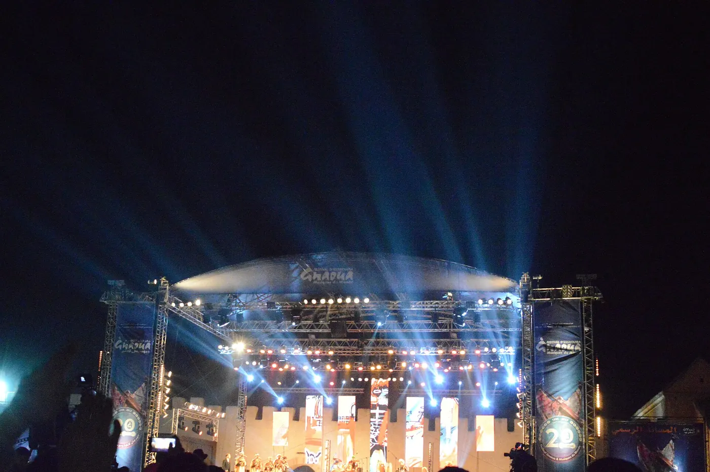 A stage lit with blue beams at night
