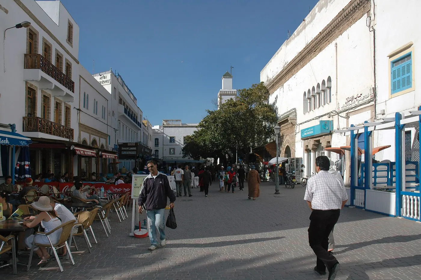 A whitewashed street in Essaouira with people walking