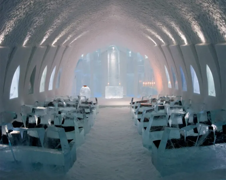 The ice church with rows of ice benches, softly lit