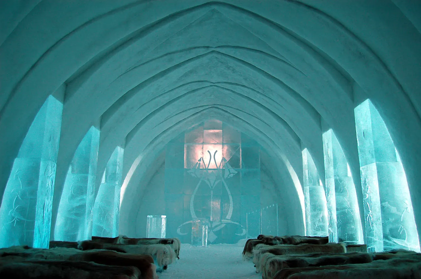 A vaulted ice hall glowing turquoise