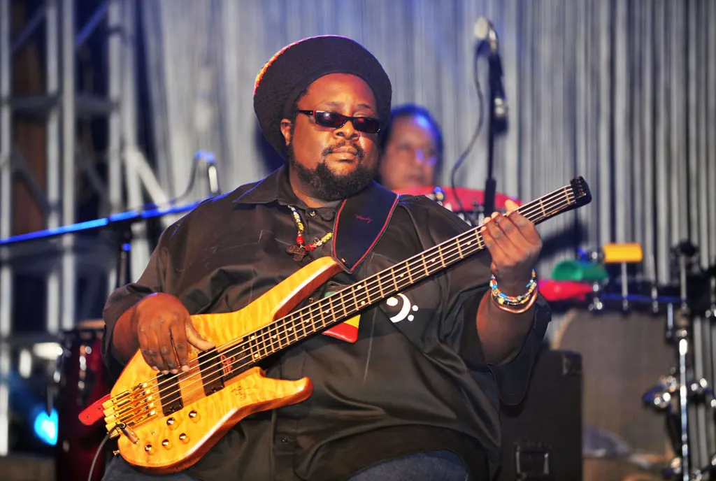 A bassist in a hat playing on stage