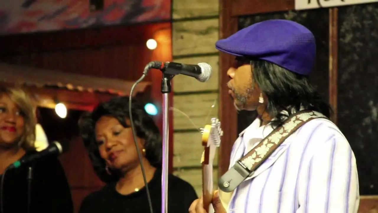 Two singers and a guitarist in a hat performing at Kingston Mines