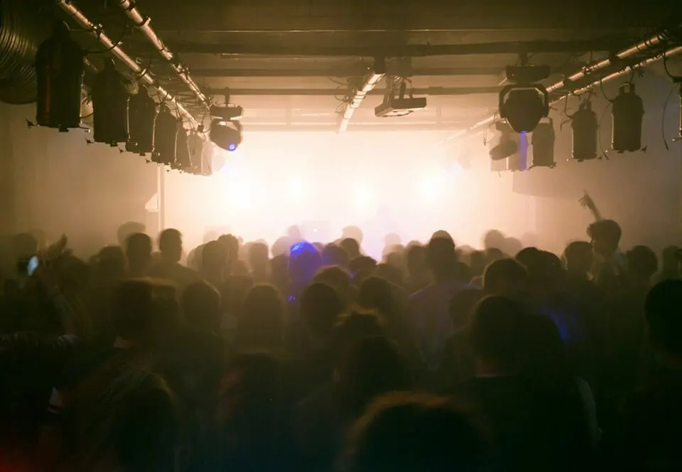 A hazy white-lit stage seen over the crowd