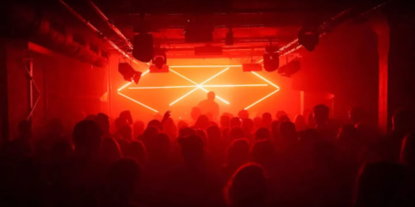 A dark room with a red neon zigzag sign