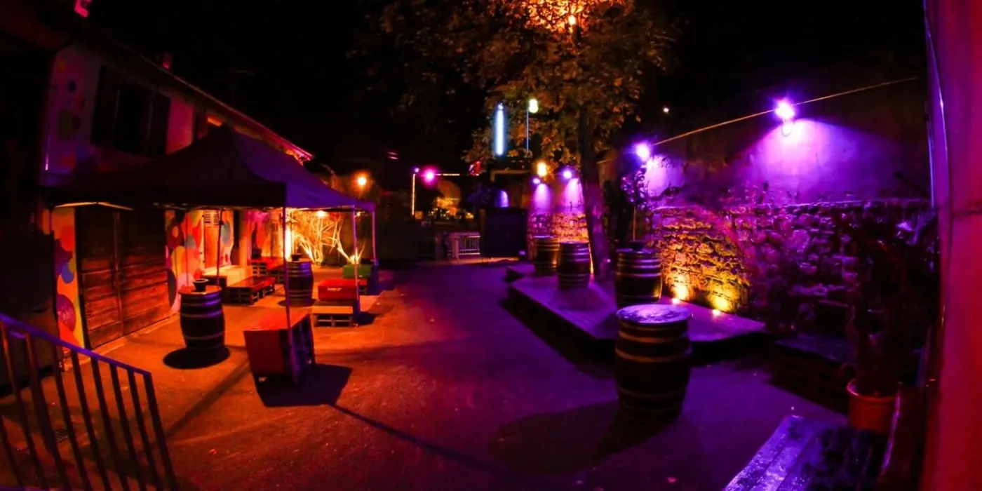 A courtyard lit in purple and orange
