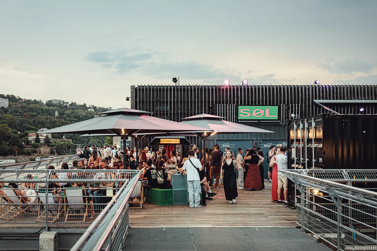 People gathering on the Le Sucre rooftop at dusk