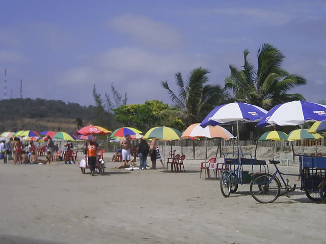 Beach umbrellas and food stalls on a sandy shore