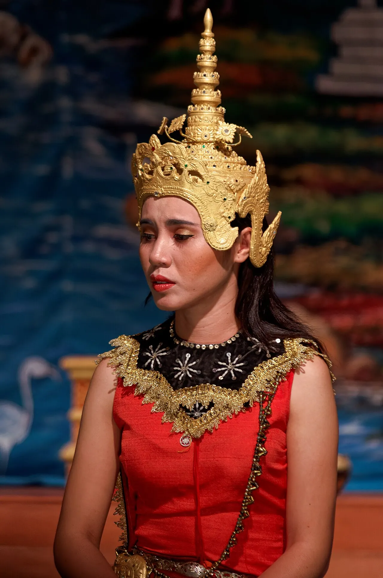 A dancer in a red costume and gold crown