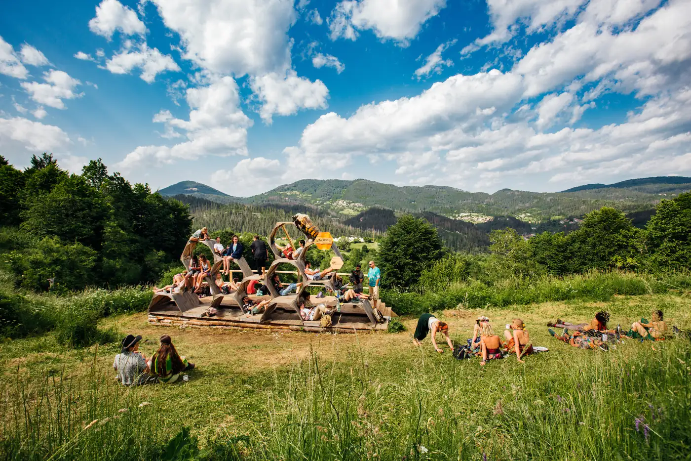 A green mountain meadow with a festival site