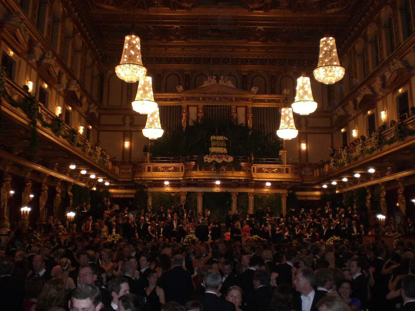 A packed Golden Hall lit by glowing chandeliers as guests in evening dress dance on the floor during the Vienna Philharmonic Ball