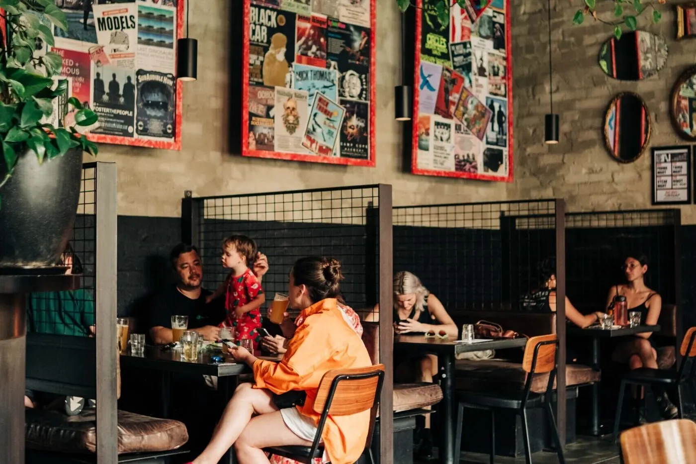 A crowd at the bar in front of a wall of posters