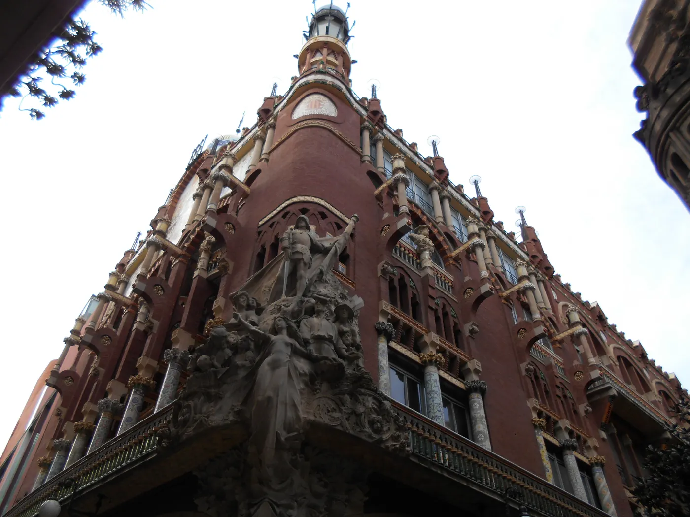 The red-brick corner facade of the Palau seen from below