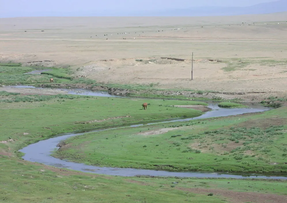 A river winding through a broad green valley
