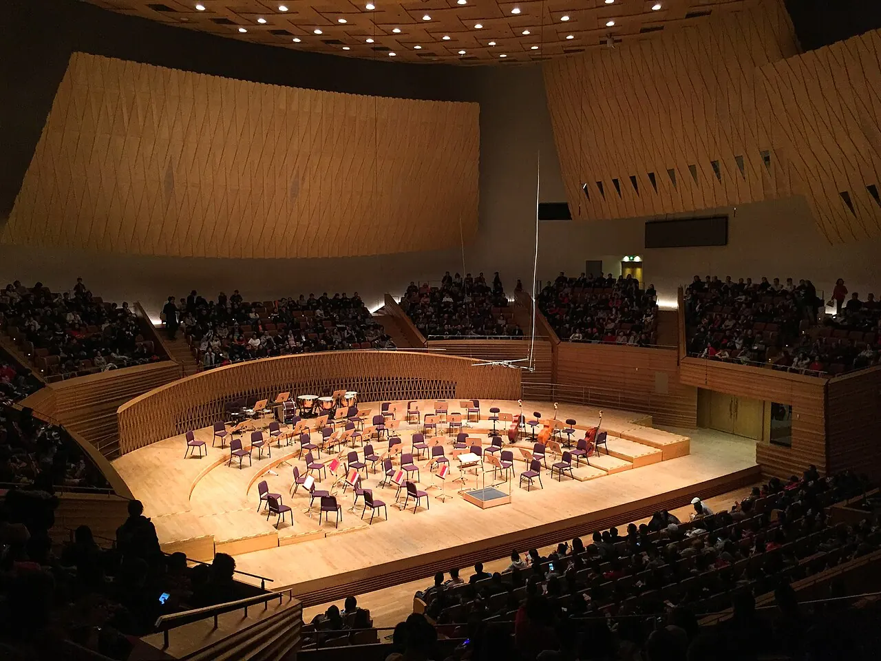 An orchestra on the platform beneath a ring of seating