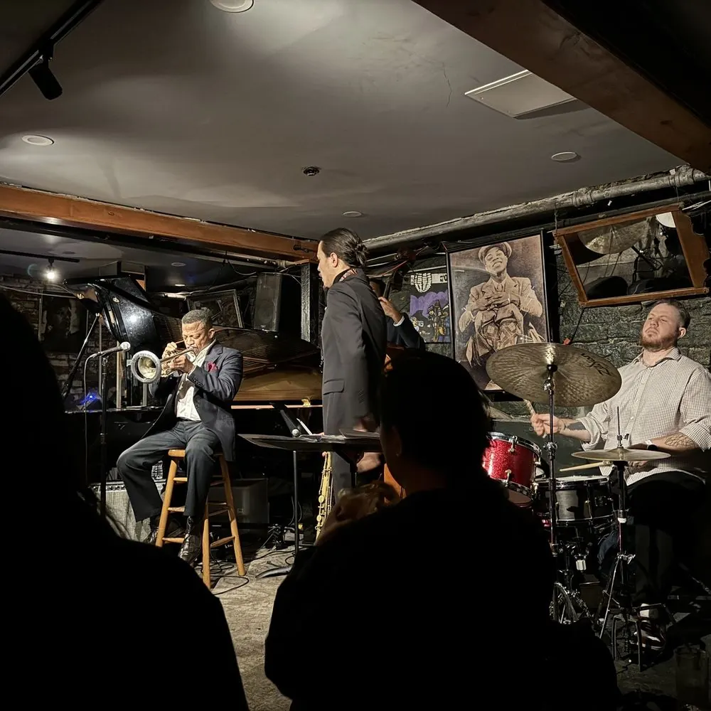 A small stage and seated audience in a low, dark room