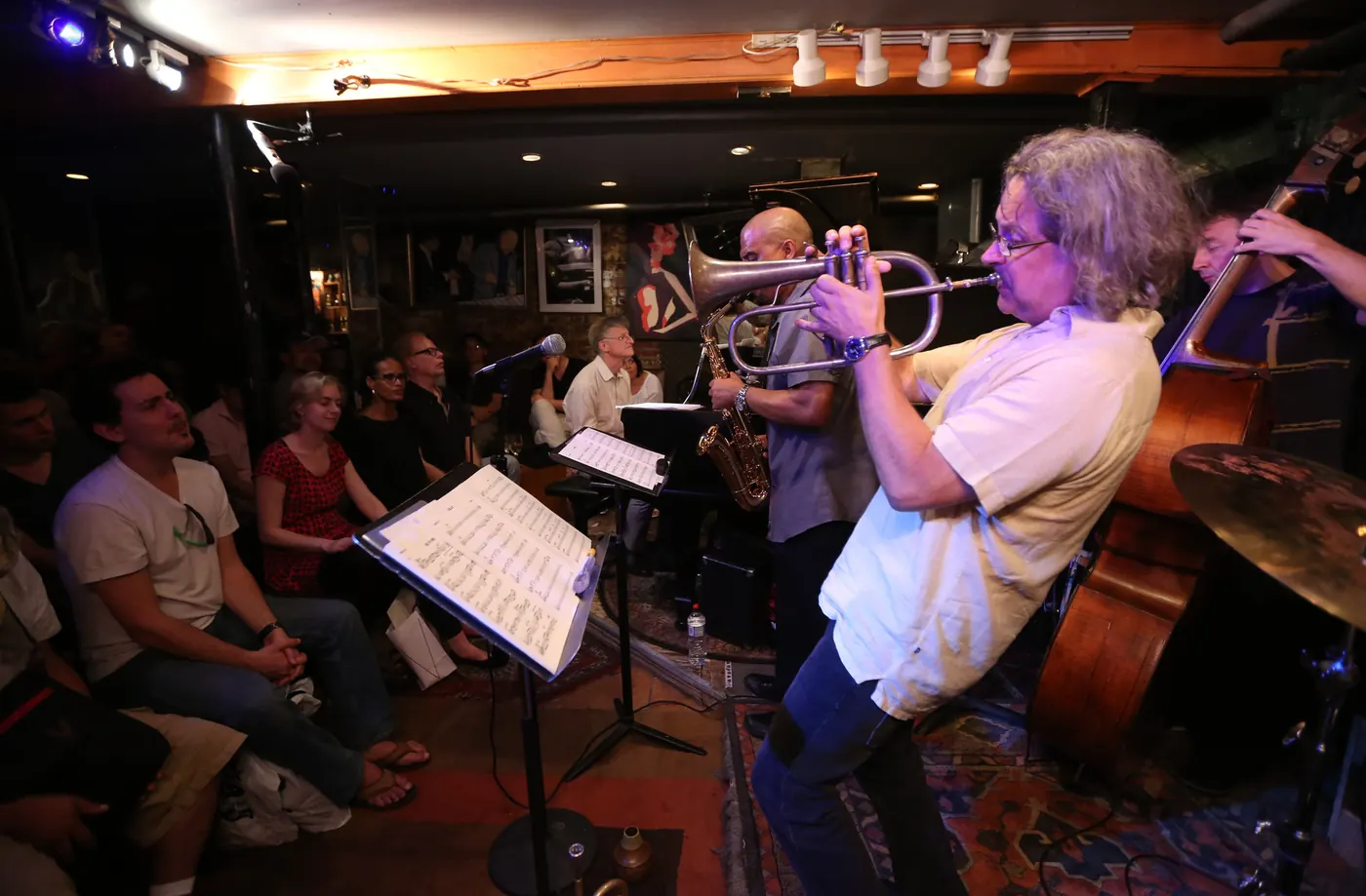 A trumpeter and a bassist playing to a seated crowd at Smalls
