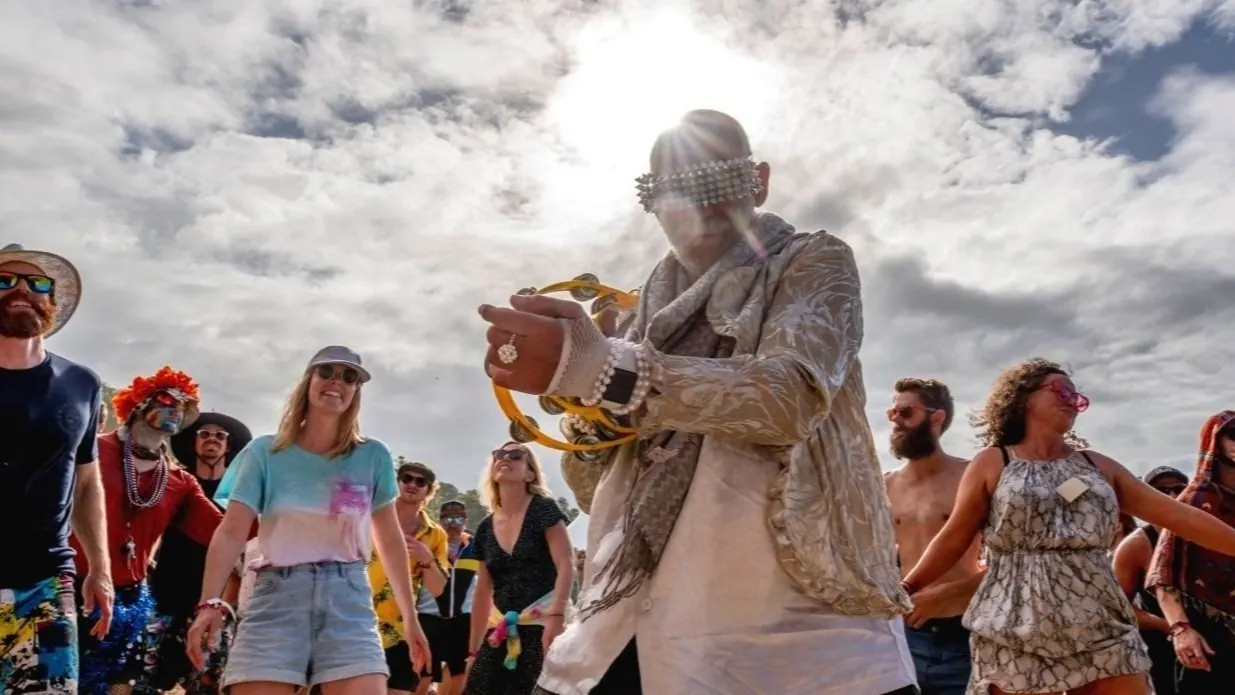 A performer in white among a crowd at Splore