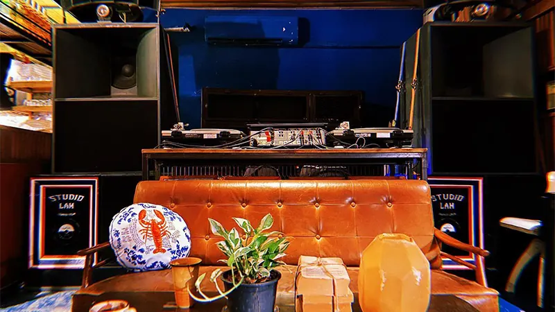 A DJ desk and warm lamps at the back of the room