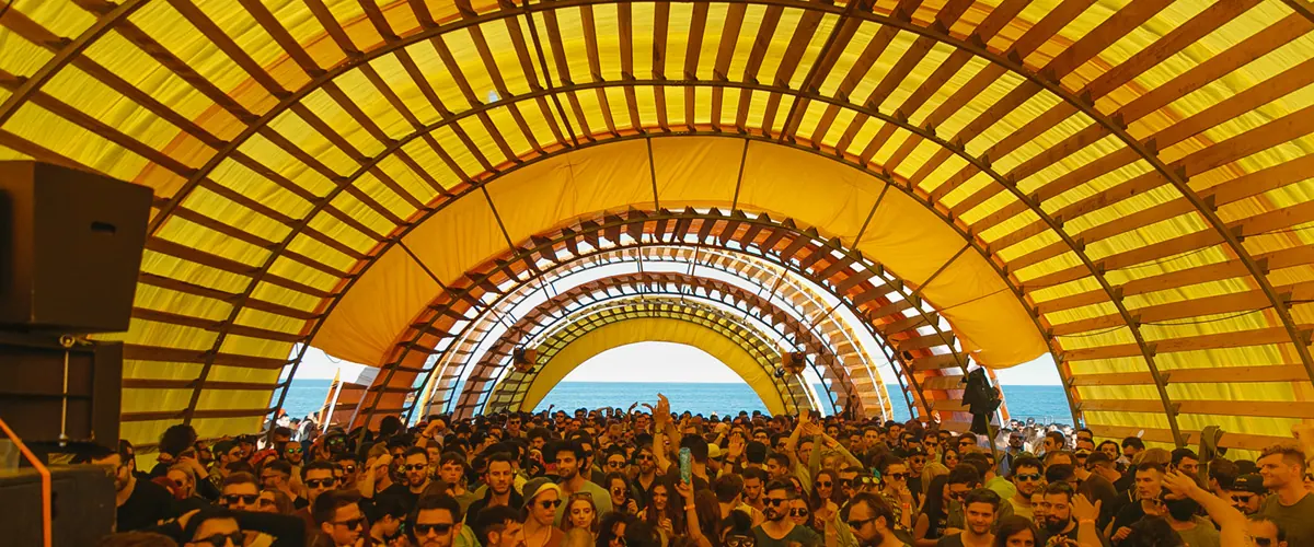 A yellow tent roof over a busy dance hall