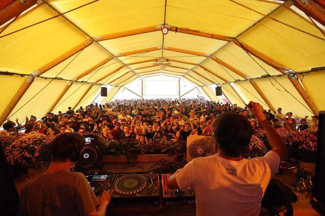 A crowd under a yellow canopy