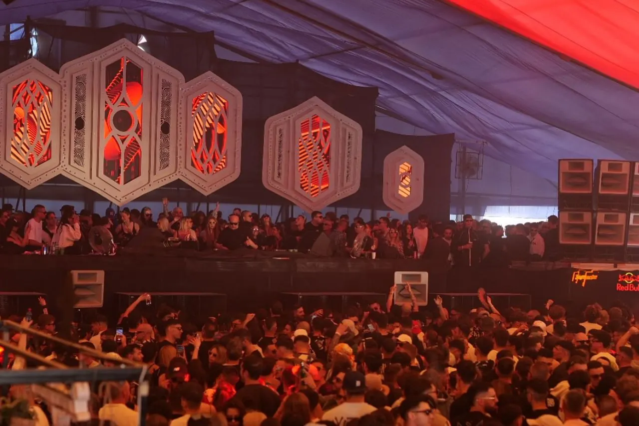 A crowd in front of a red stage with lanterns