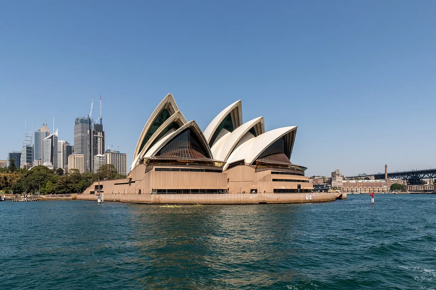 The Opera House seen across the water with the city skyline behind
