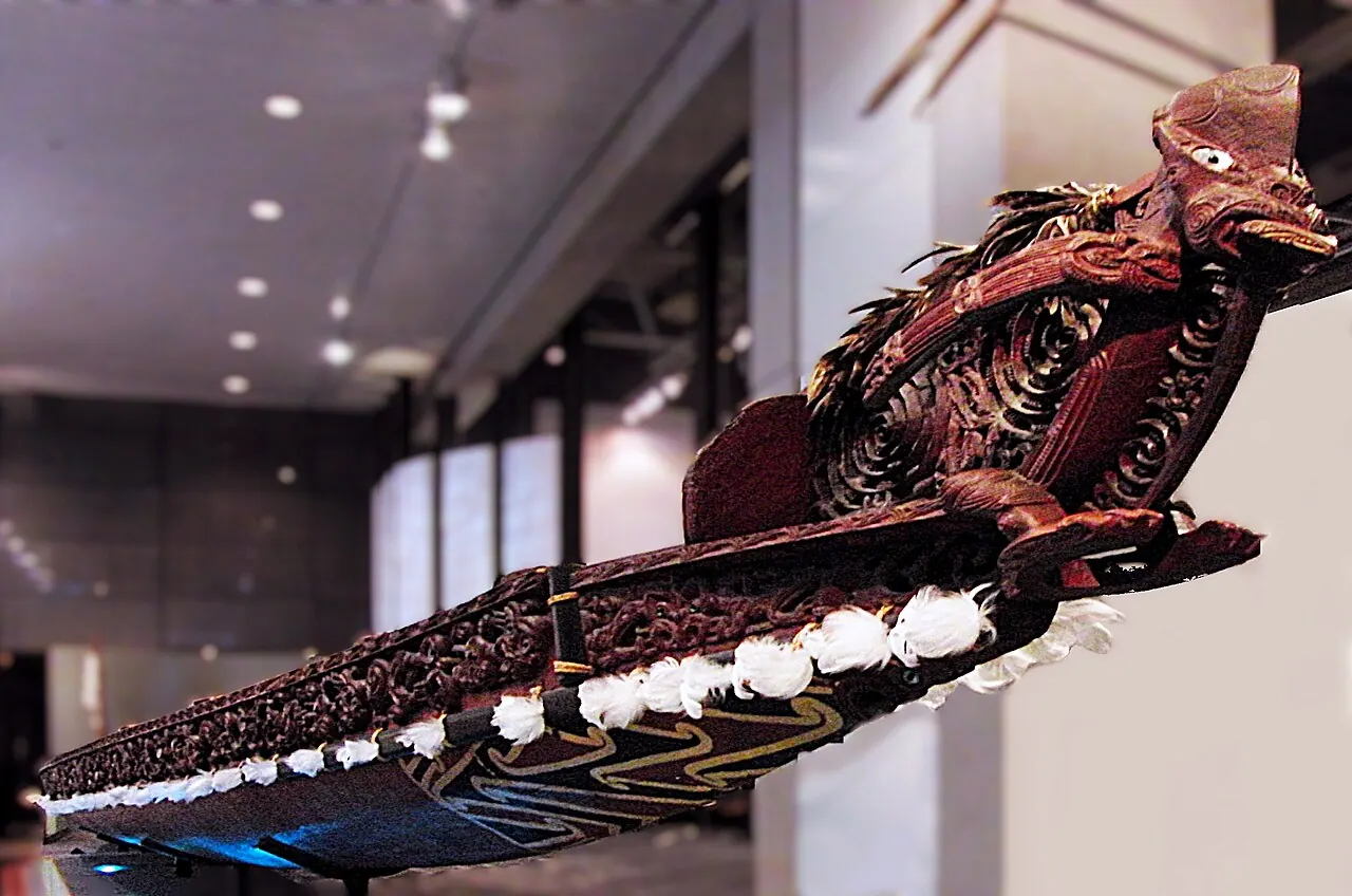 The prow of a carved canoe in a gallery