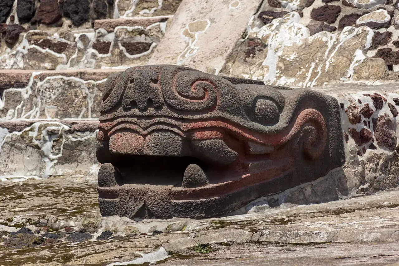 A serpent sculpture and stonework among the excavated ruins