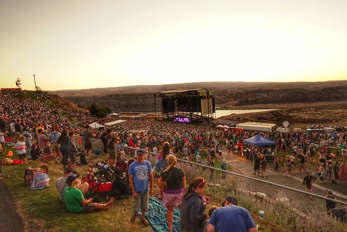 A crowd on the grass terraces in golden evening light