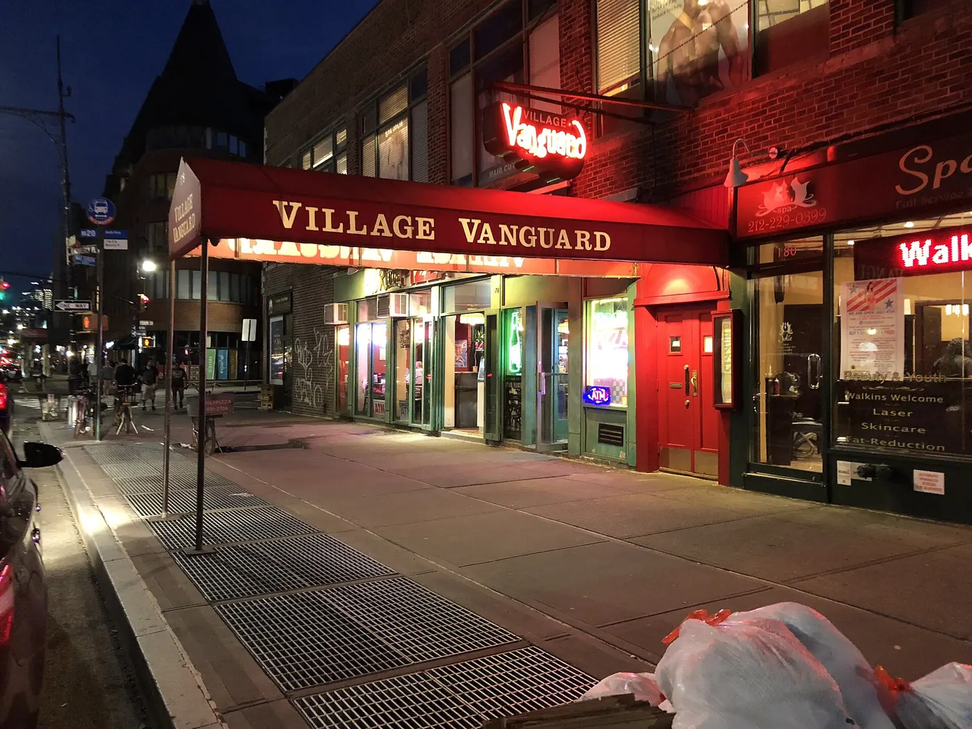 The red awning lit at night on a quiet street