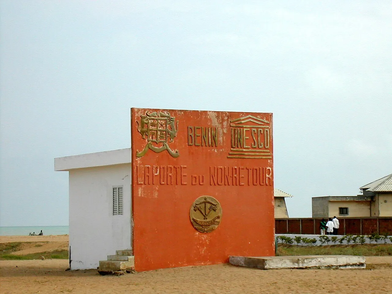 A sun-bleached building with an orange wall in a coastal village