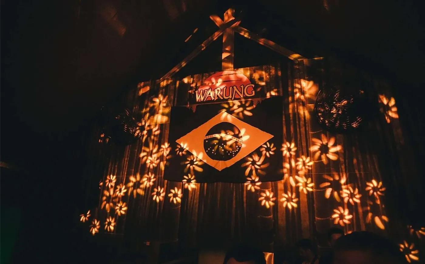 A dark timber building outlined in lights