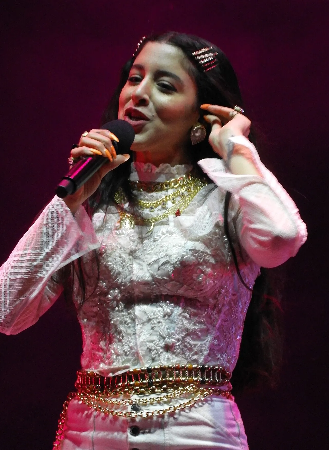 A singer in a silver jacket performing