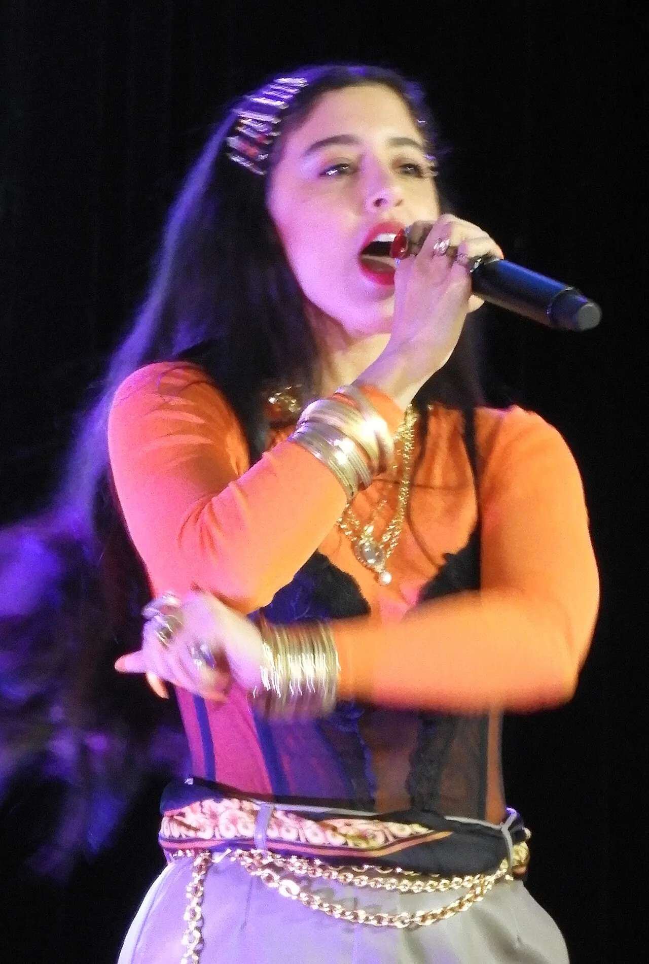 A singer in a purple jacket performing