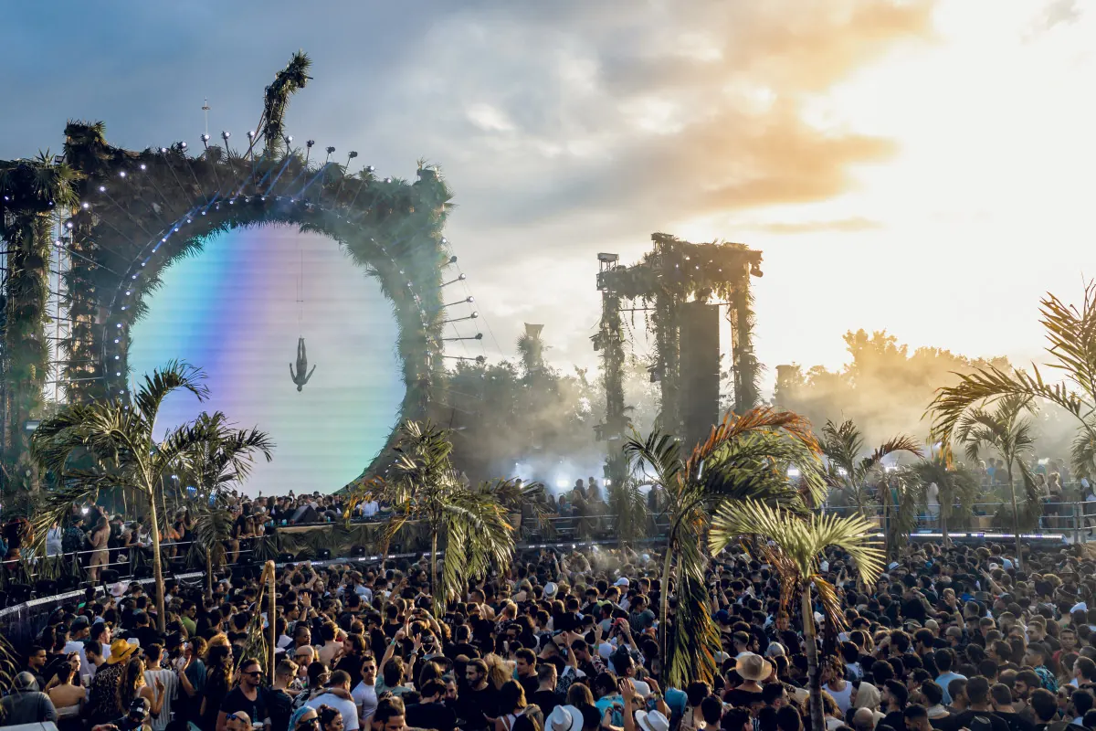 A large stage with a mirrored disc rising over the crowd
